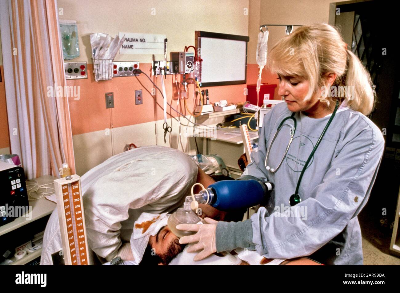 Using an oxygen mask, an emergency room trauma team doctor treats a patient at a hospital in Mission Viejo, CA. Stock Photo