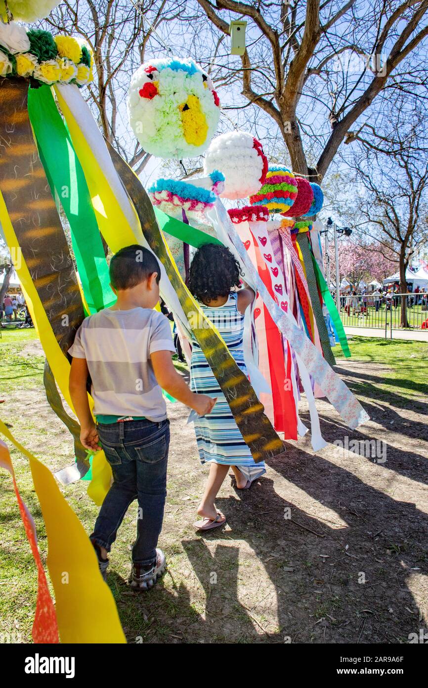 Children run through Tanabata ribbons at a Japanese festival in