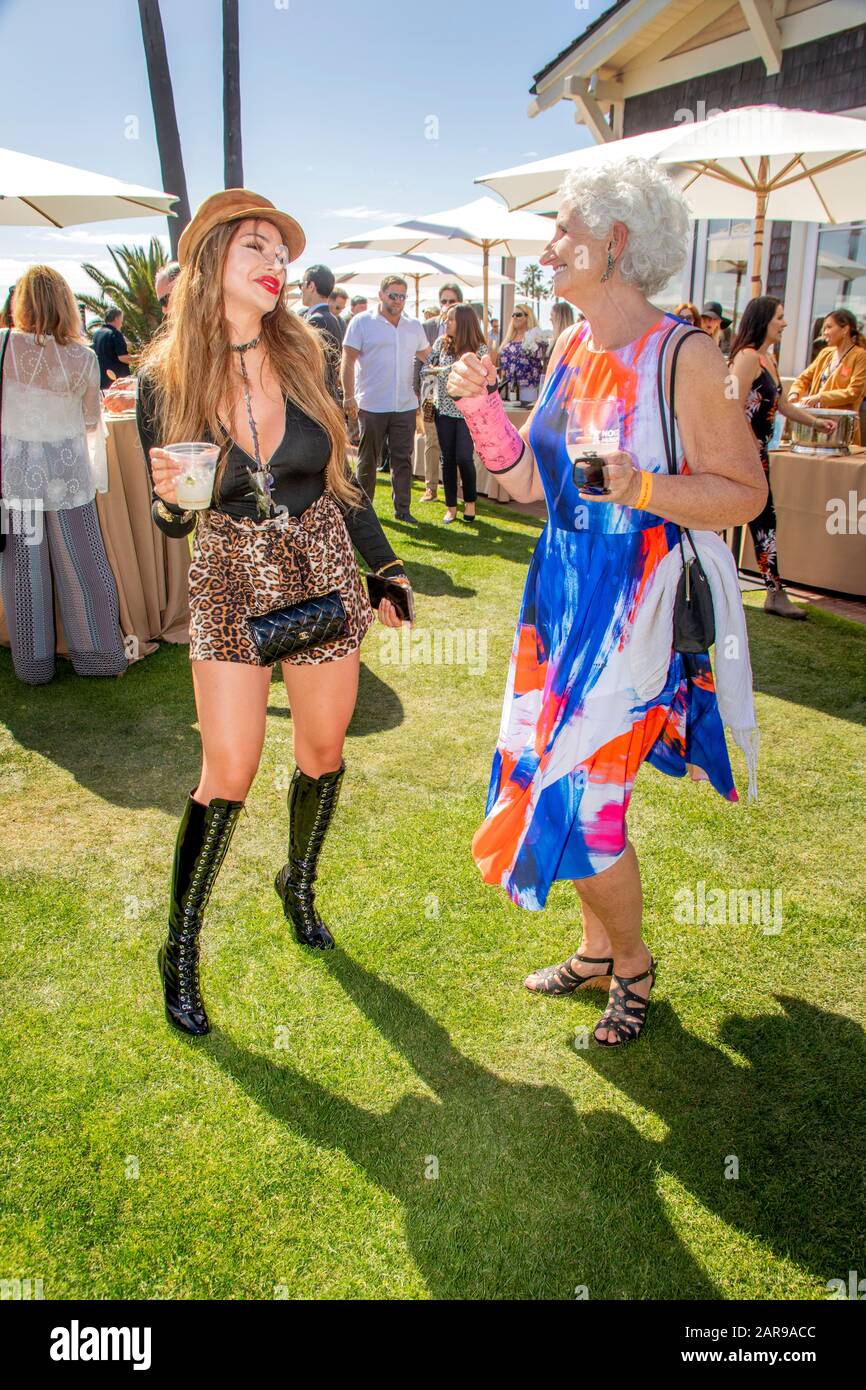 Fashionably dressed women dance during an outdoor gourmet celebration at a luxury resort hotel in Laguna Beach, CA. Stock Photo