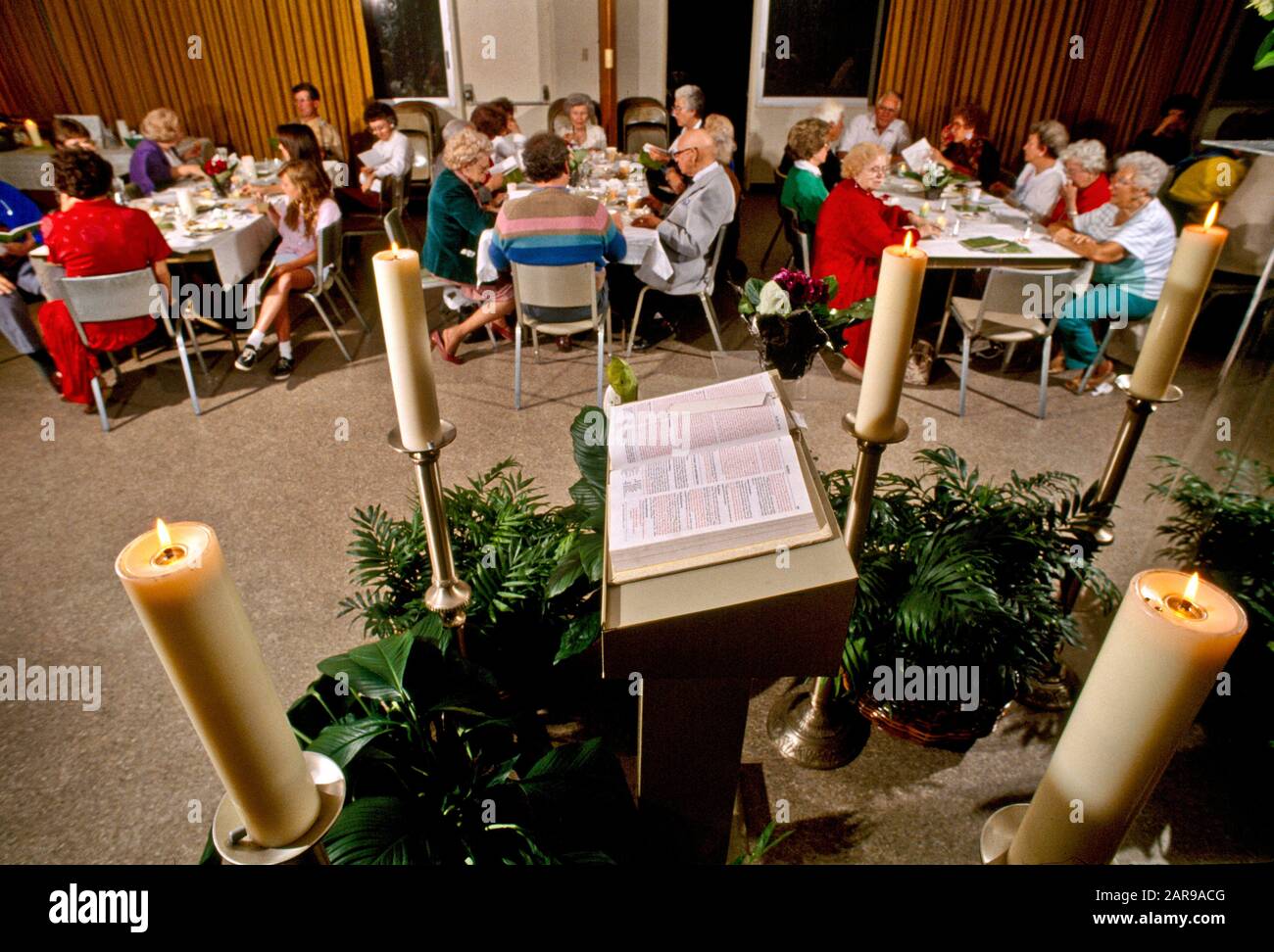 Surrounded by candles, a Bible is displayed at a Jewish seder dinner in Laguna Beach, CA. The Passover Seder is a Jewish ritual feast that marks the beginning of the Jewish holiday of Passover. Stock Photo