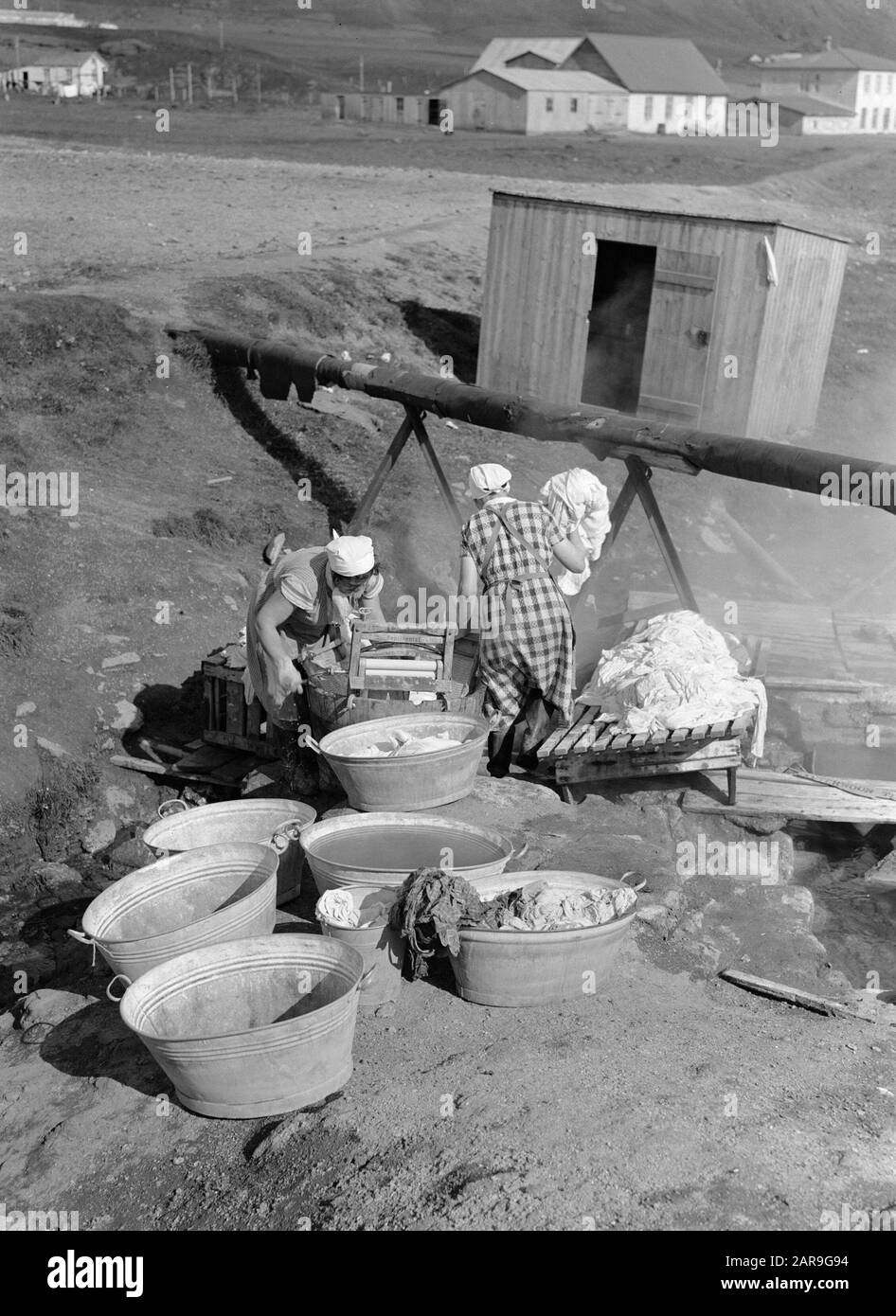 Iceland Women washing at a hot spring. On the wastobbe is a wringer