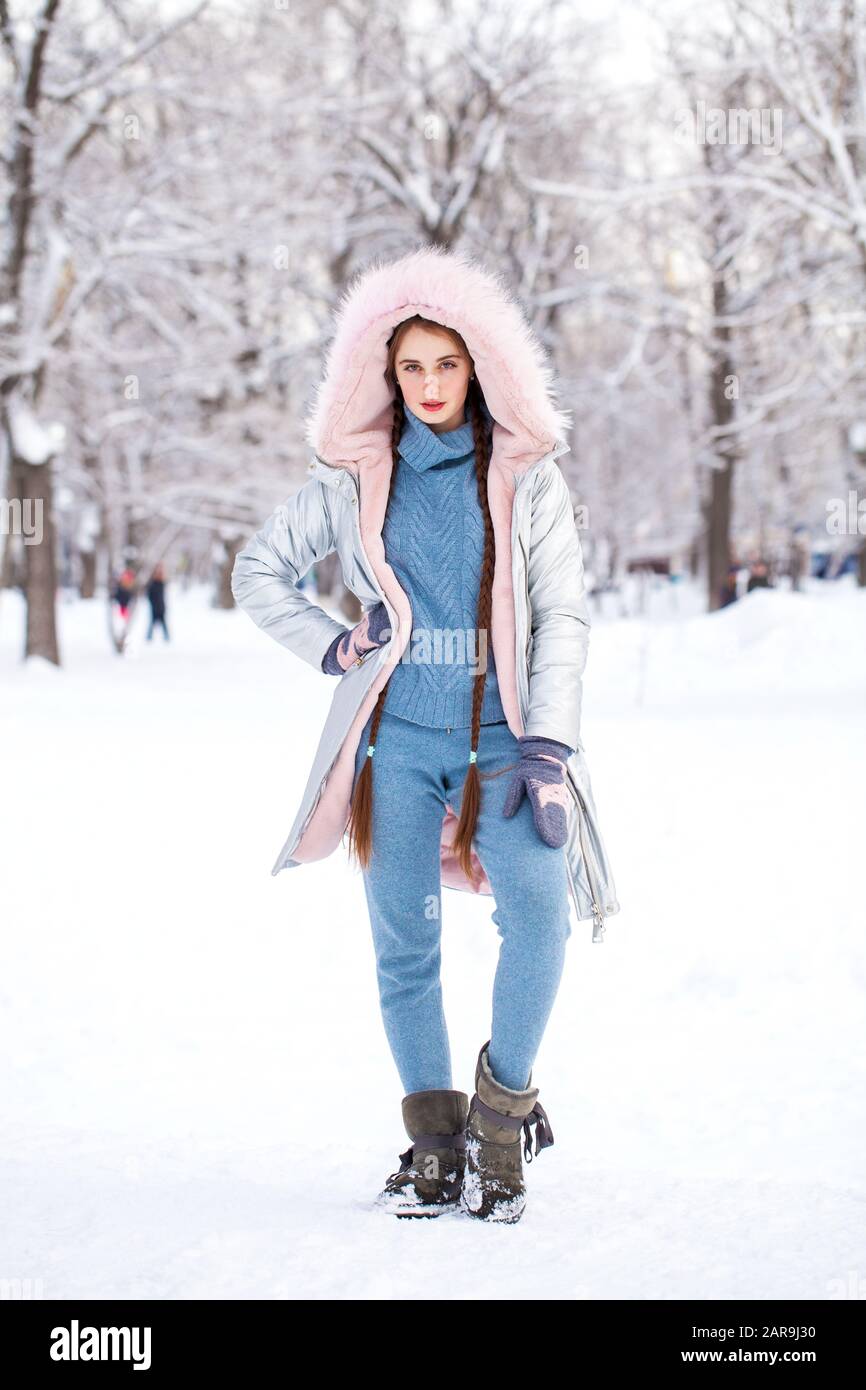 Full body portrait of a young beautiful girl in down jacket posing