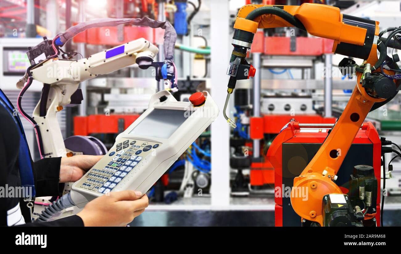 Engineer check and control modern high quality automation welding robots arm at industrial Stock Photo