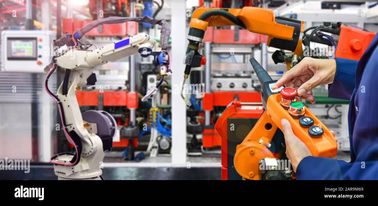 Engineer check and control modern high quality automation welding robots arm at industrial Stock Photo