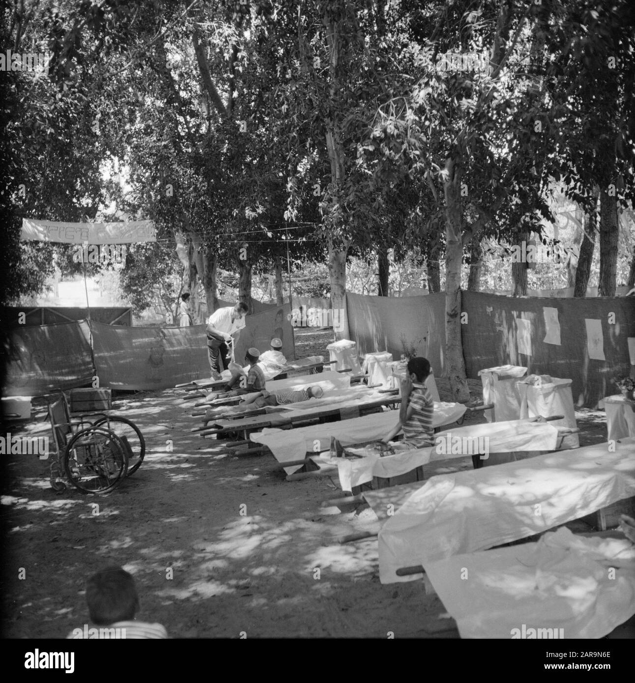 Summer camp for spastic children at Rehovot (Vera Weizmann summer camp for post polio children). Children rest in the shade of the trees on field beds. Left a wheelchair Date: undated Location: Israel, Rehovot Keywords: disabled facilities, children, polio, rehabilitation, holiday camps, fieldbeds Personal name: Weizmann, Vera Stock Photo