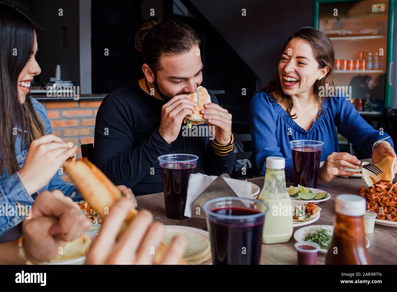 Mexican people eating Tacos al Pastor in a Taqueria in Mexico city Stock Photo