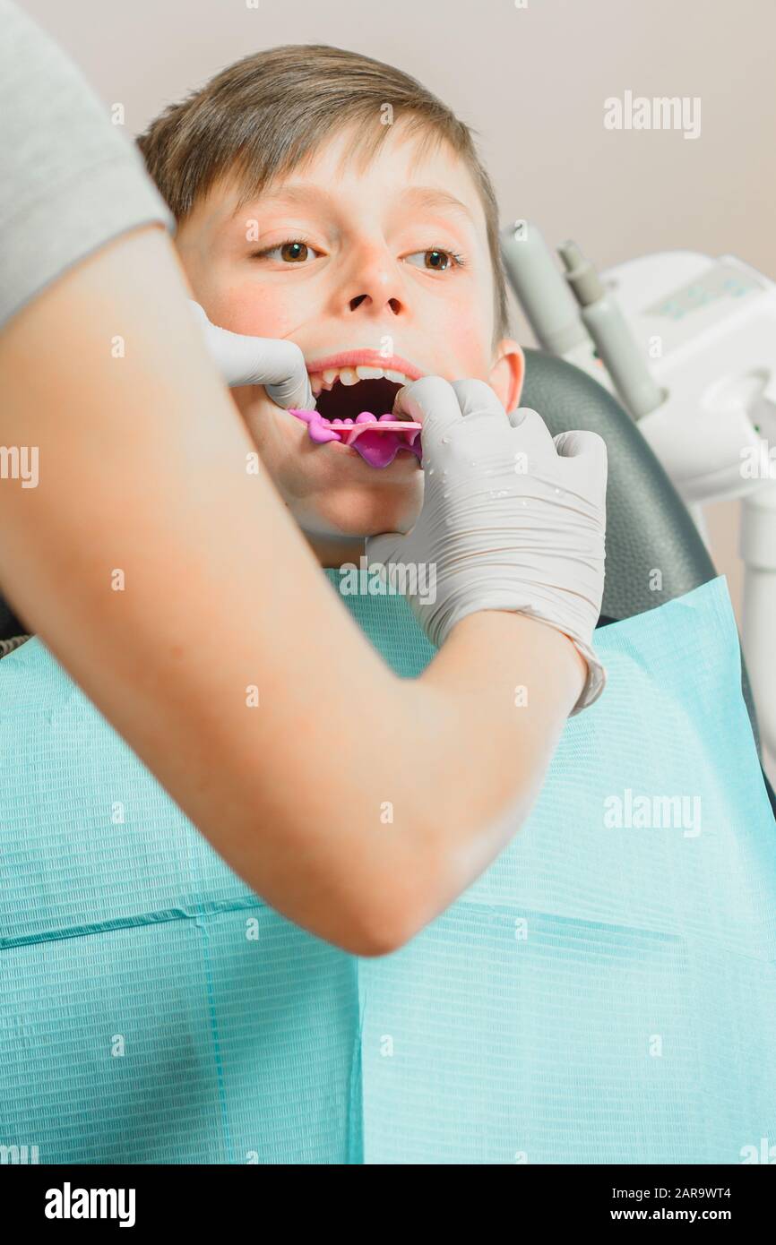 Boy in dentist chair with dental impression tray in her mouth Stock Photo Alamy