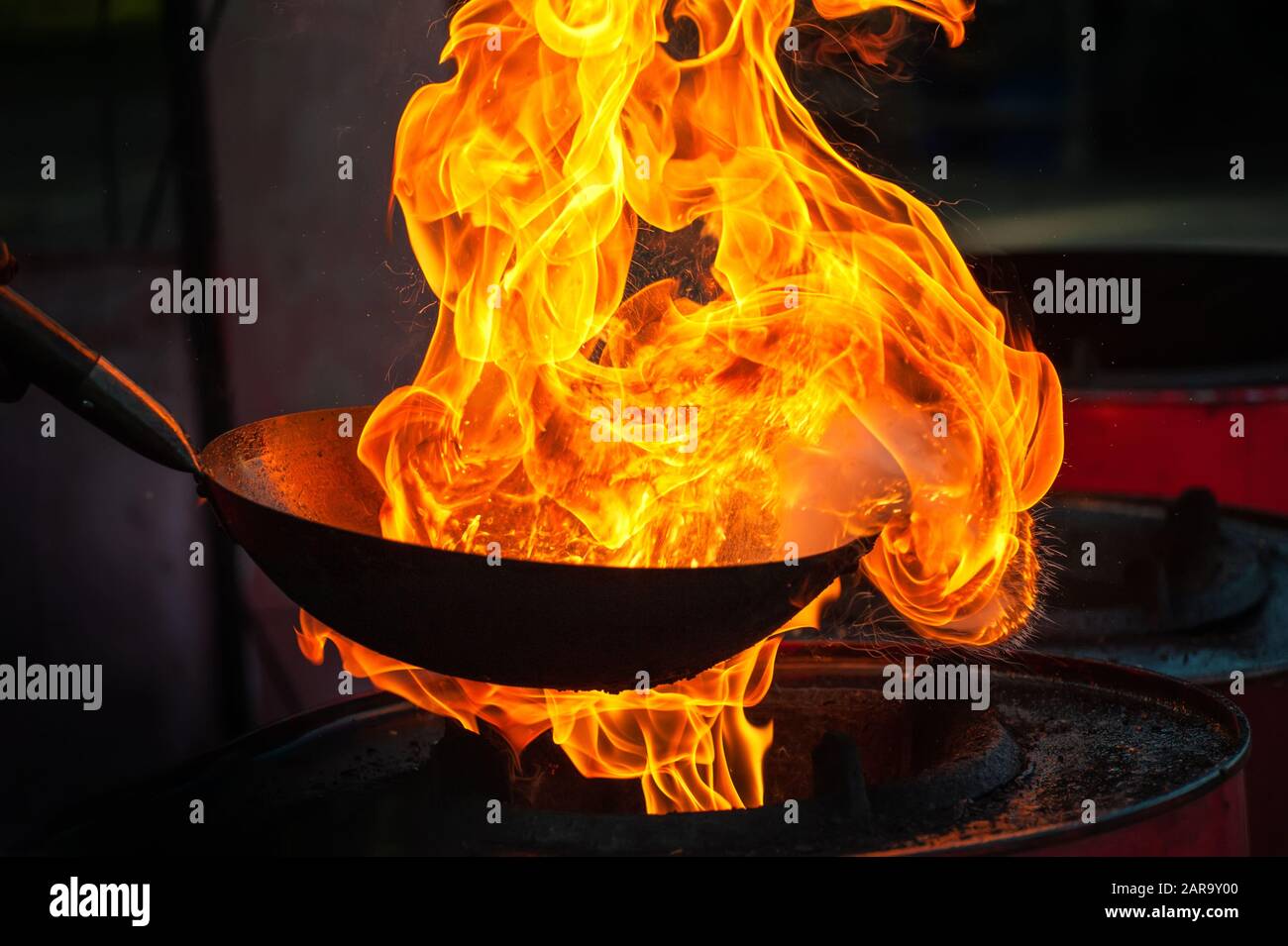 Chef cooking with fire in frying pan on street Stock Photo Alamy