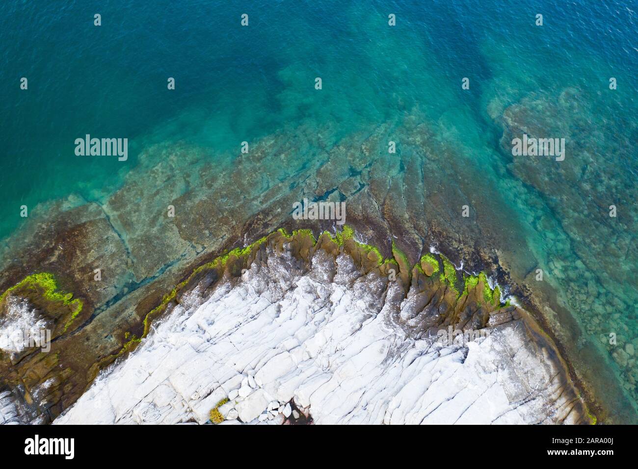 Aerial view from flying drone of a little rocky island in open sea in