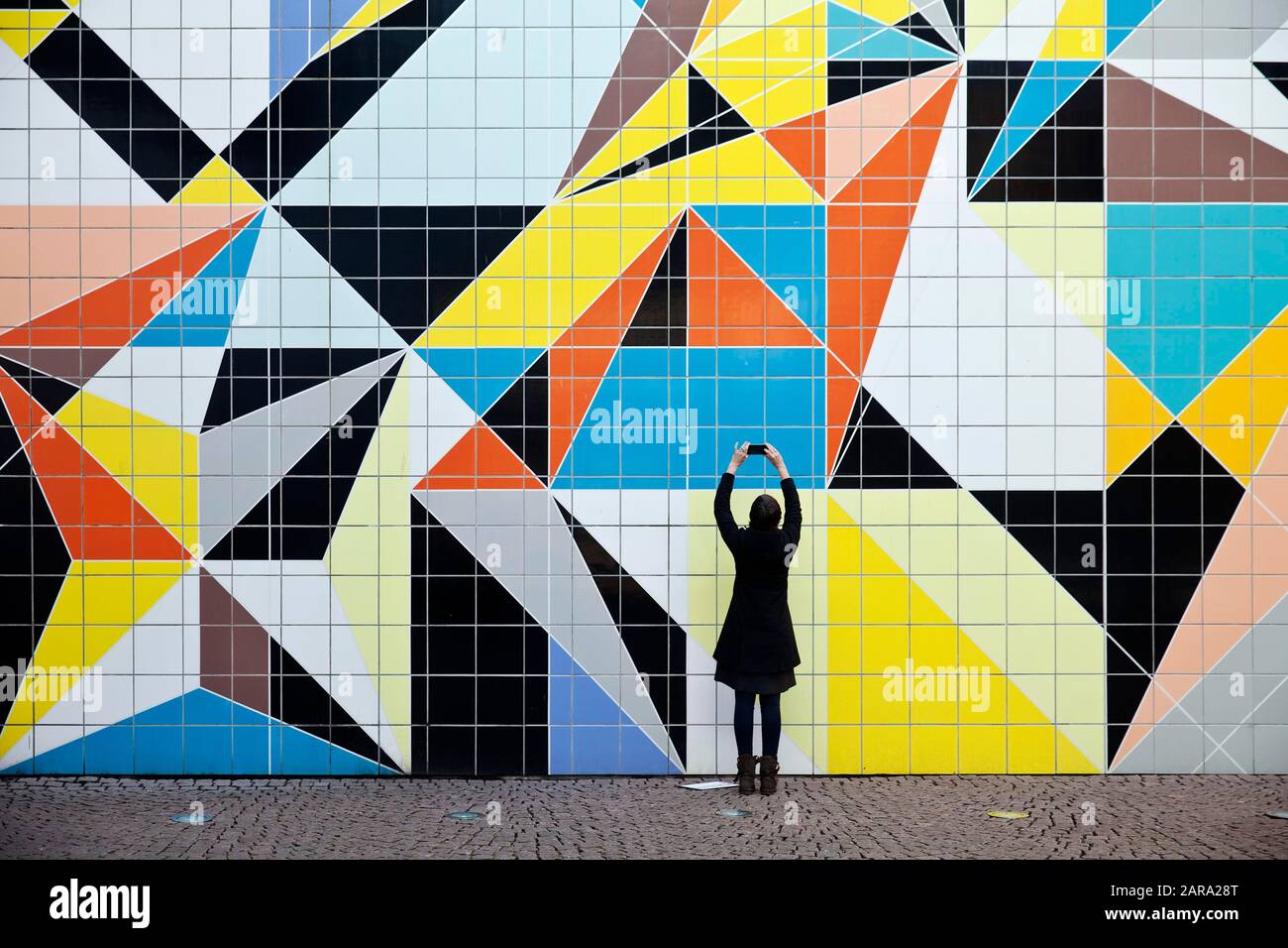 A woman photographs the mural Hornet, artist Sarah Morris, Paul Klee-Platz at the art collection, Duesseldorf, North Rhine-Westphalia, Germany Stock Photo