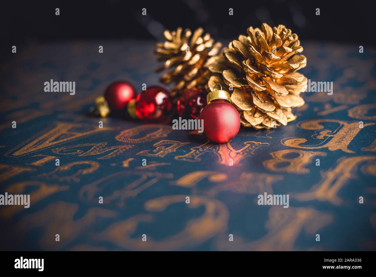 Christams gold pine conre and red glass ball decoration on vintage type pattern table background.holiday greeting card with copy space Stock Photo