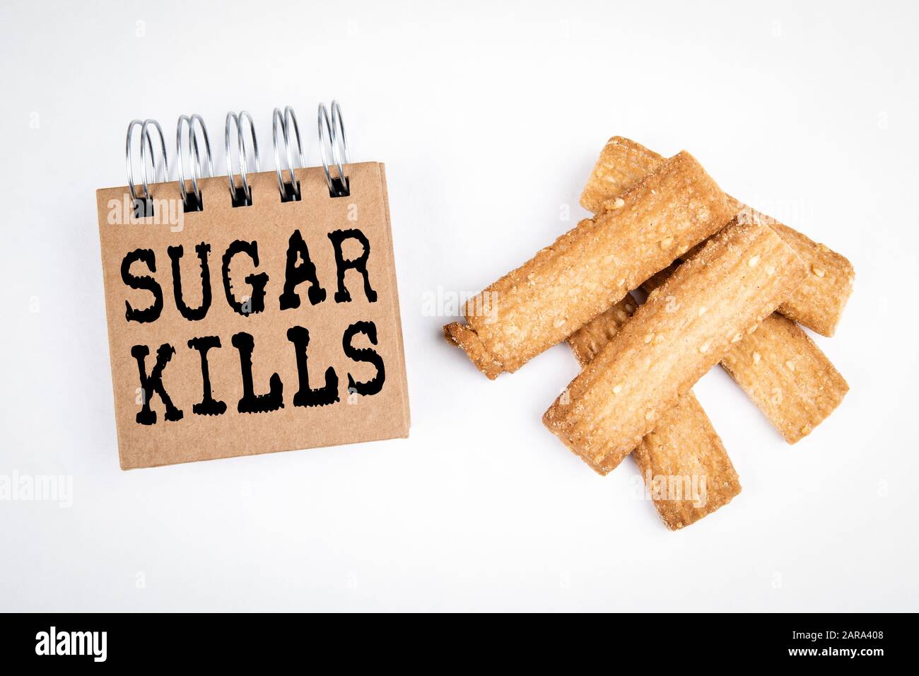 Sugar Kills. Diabetes, heart, obesity and unhealthy concept. Biscuits with sesame seeds on a white background Stock Photo