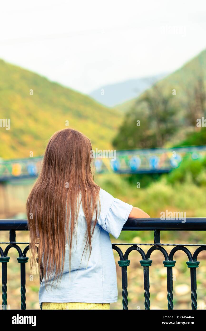 Little girl on the embankment of a mountain river in the city Stock ...