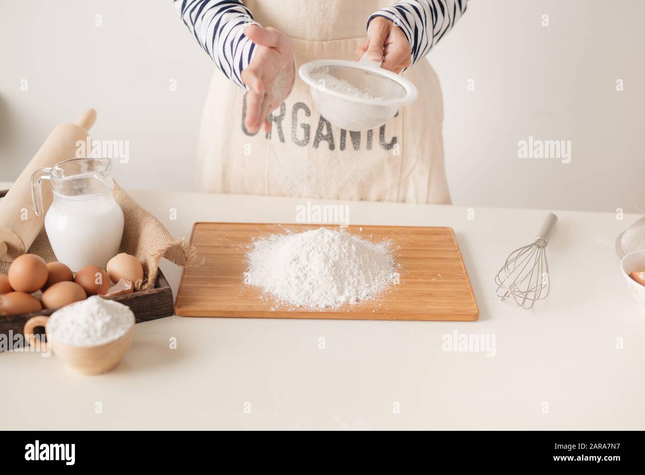 Flour sifting through a sieve for a baking Stock Photo Alamy