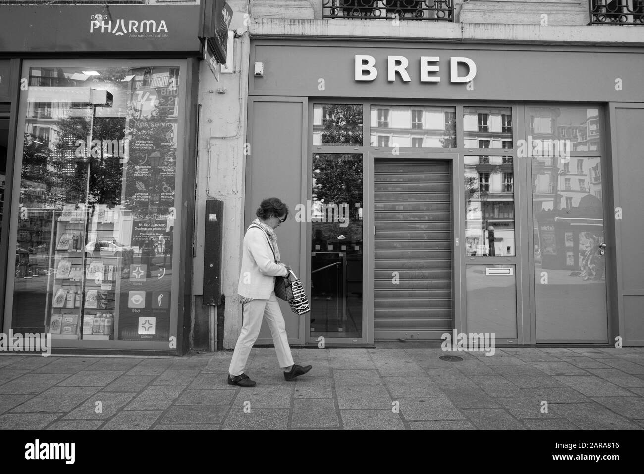 Woman walking on pavement, Bred Bank, Rue Saint Antoine, Paris, France, Europe Stock Photo