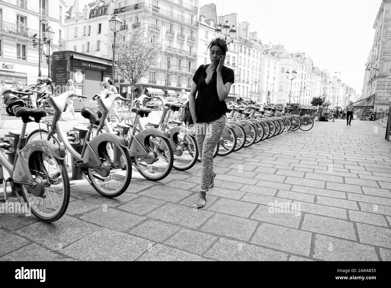 Paris Bike Racks Woman walking on pavement, bicycle parking rack, Rue Saint Antoine ...