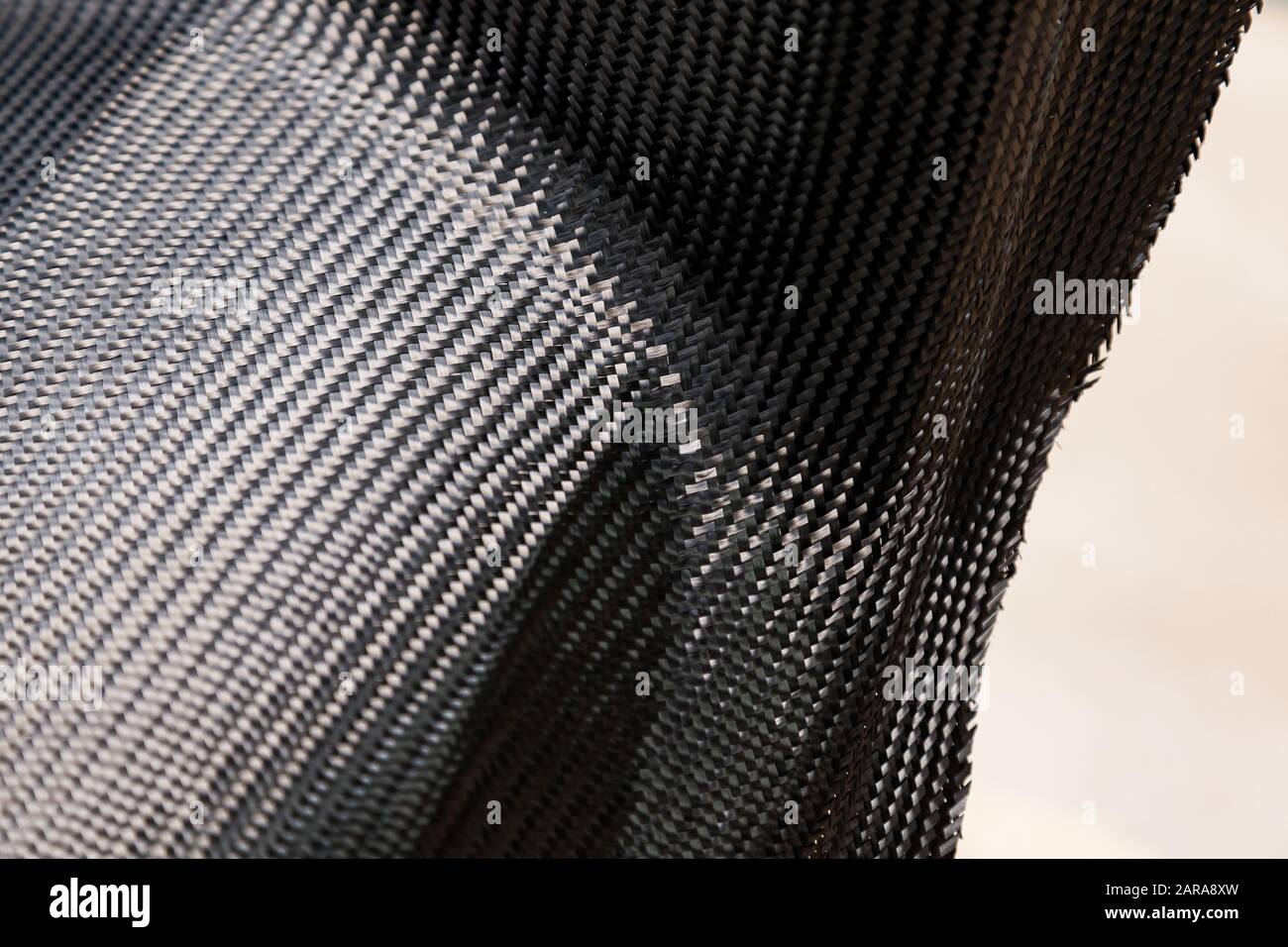 A closeup on a carbon fiber background of interwoven black and gray color from heavyduty yarns