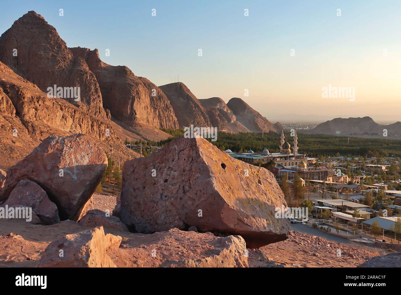 Saheb Zaman Mosque cemetery behind  desert mountains and forest, Kerman Iran Stock Photo
