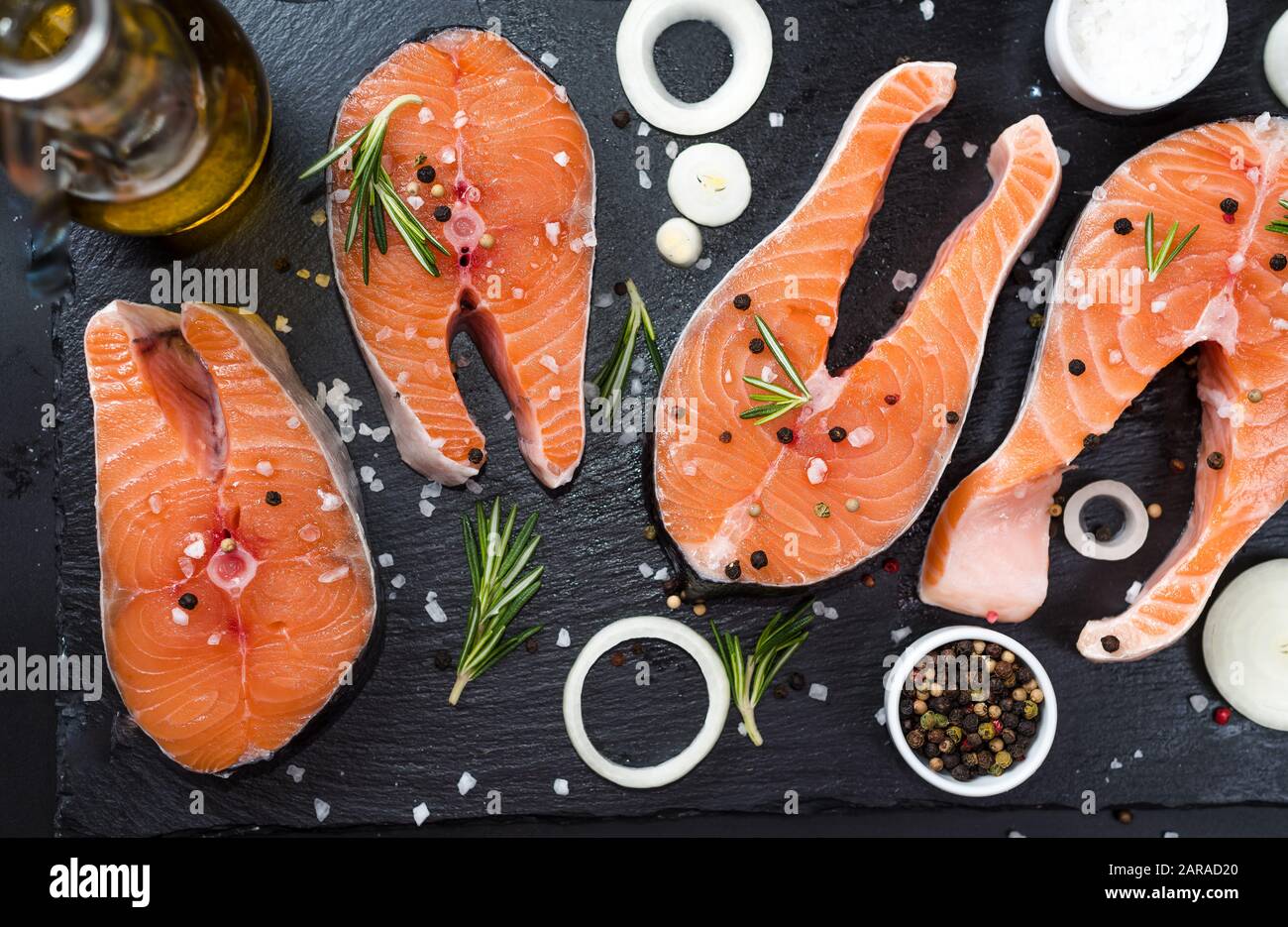 Raw salmon fish steaks with fresh herbs on cutting board Stock Photo ...