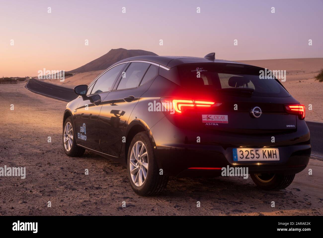 Opel Astra Turbo Belongs to the Cicar car rental company by the road through the dunes - Canary Islands, Fuerteventura - January 2020 Stock Photo