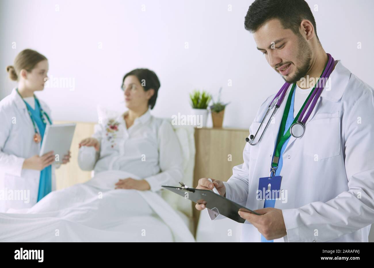 Patient with a group of doctors at the background Stock Photo Alamy
