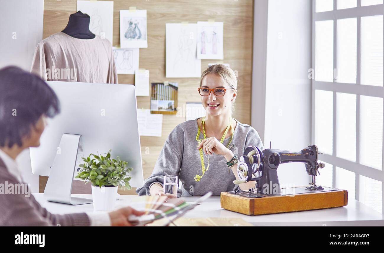 pretty dressmaker showing a new design to her client Stock Photo - Alamy