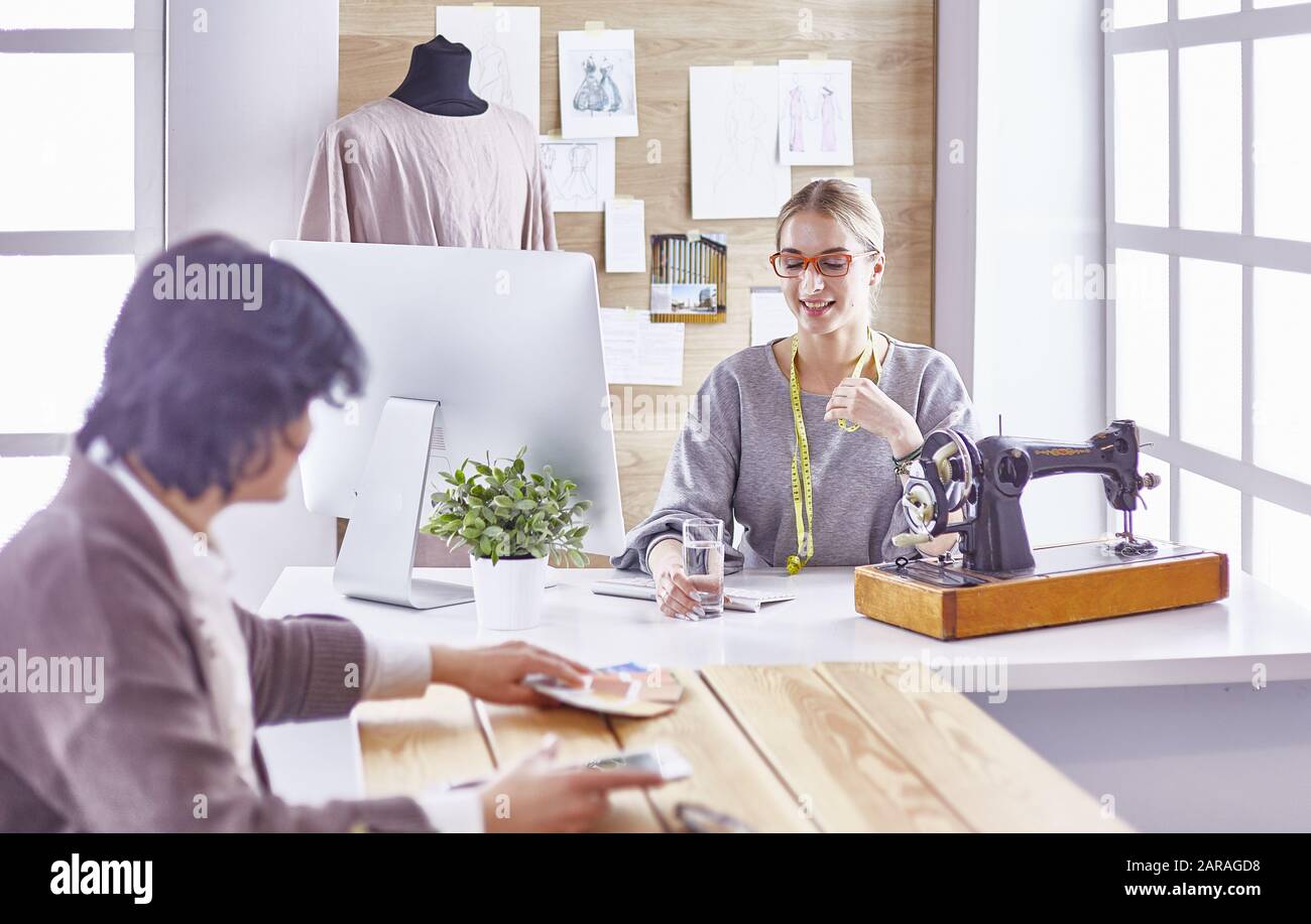 pretty dressmaker showing a new design to her client Stock Photo - Alamy