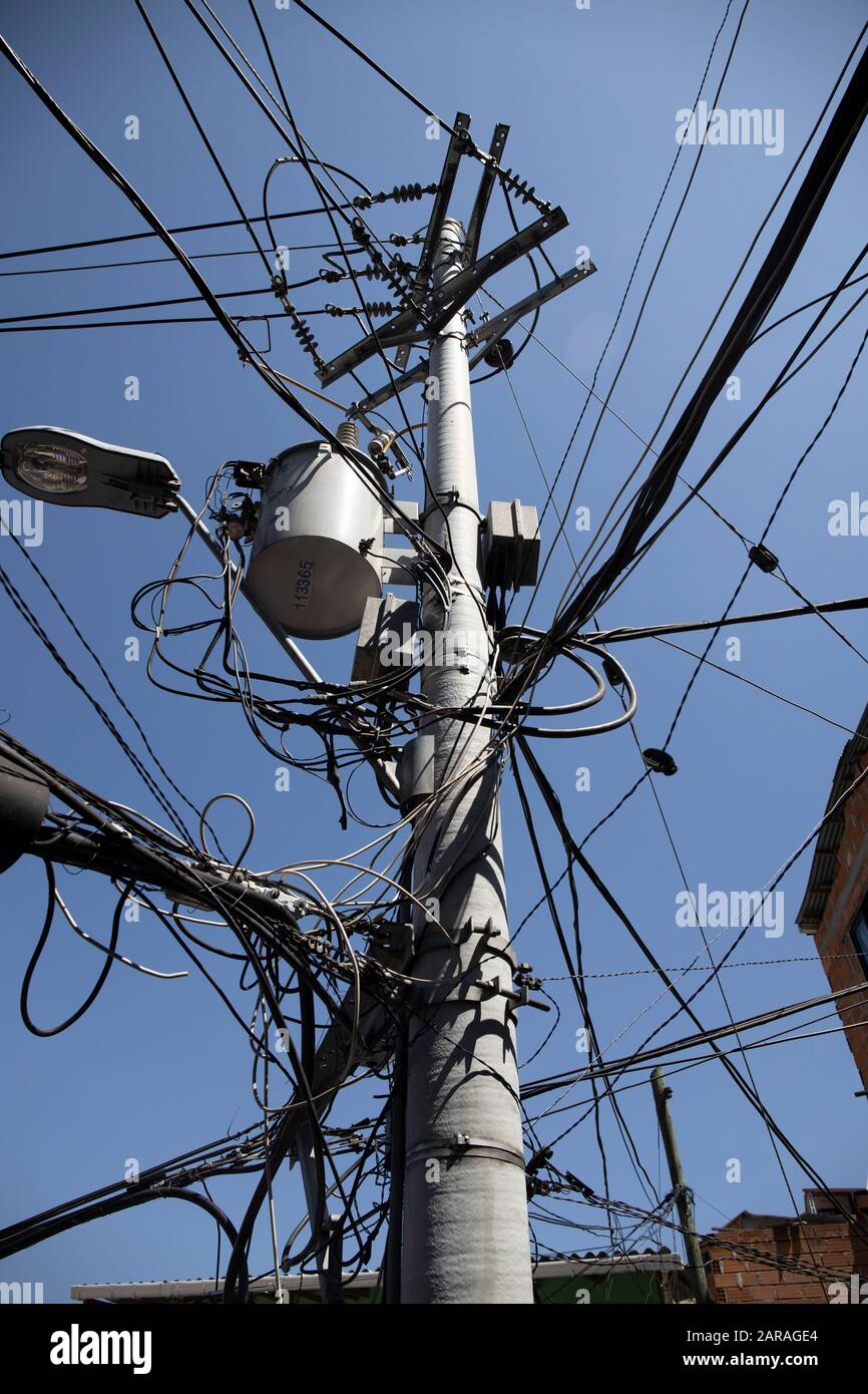 Medellin: Comuna 13, these days the area is known for the graffiti/ street art which has helped transform this area. Power provided by overhead cables. Stock Photo