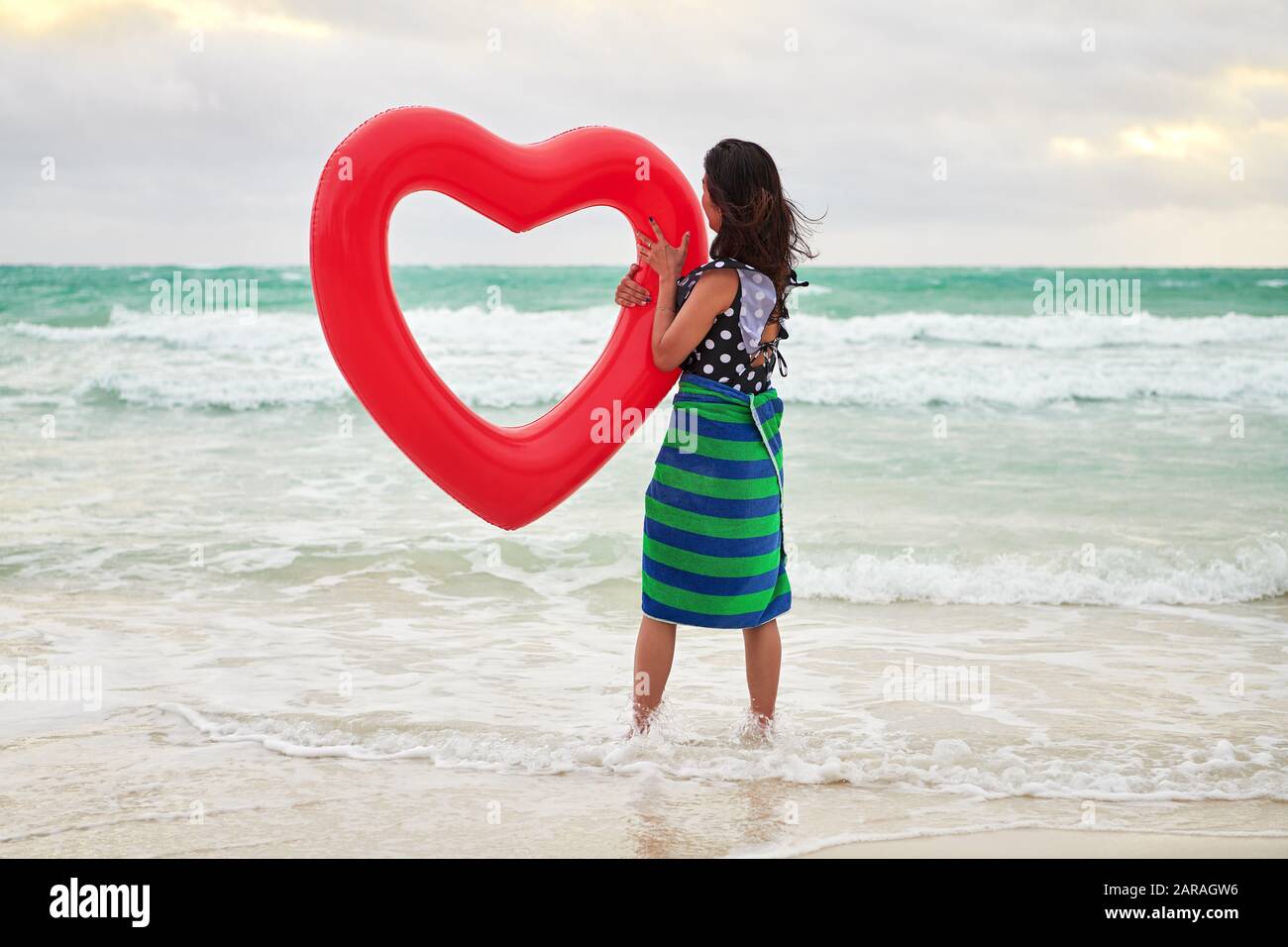 Boracay, Aklan Province, Philippines - December 3, 2019: A young Chinese woman is holding a red heart shaped air ring at the empty White Beach Stock Photo