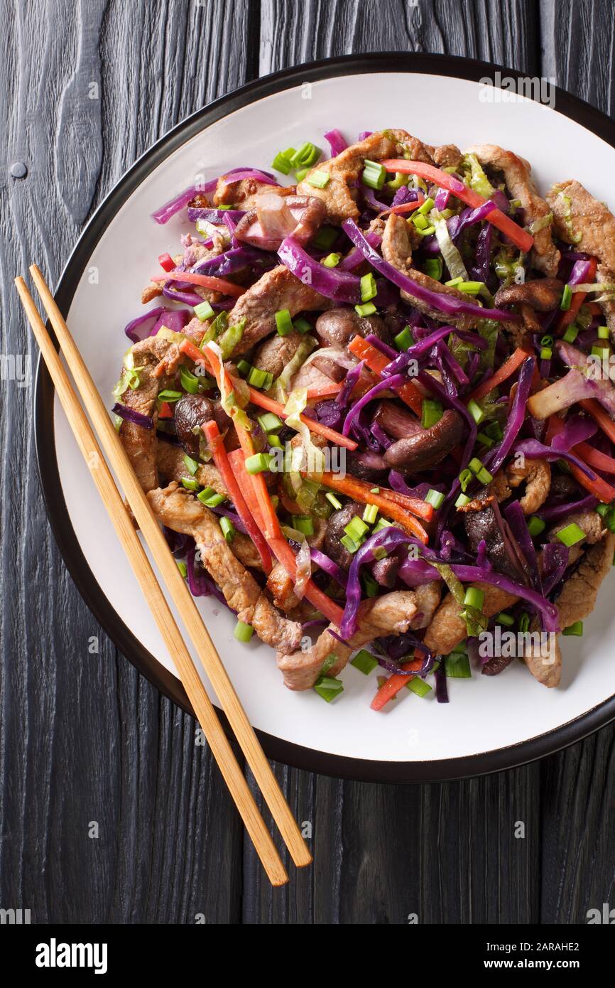 Hot chinese pork moo shu with vegetables close-up in a plate on the table. Vertical top view from above Stock Photo