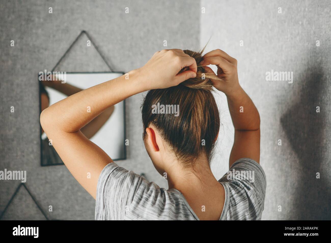 Girl does hairstyle or hair style in front of a mirror in the room Stock  Photo - Alamy