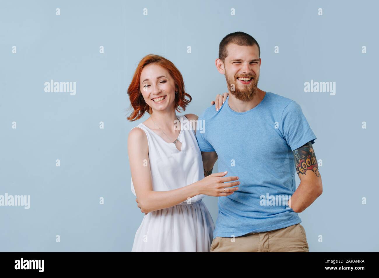 Happy couple at home laughing over blue background Stock Photo - Alamy