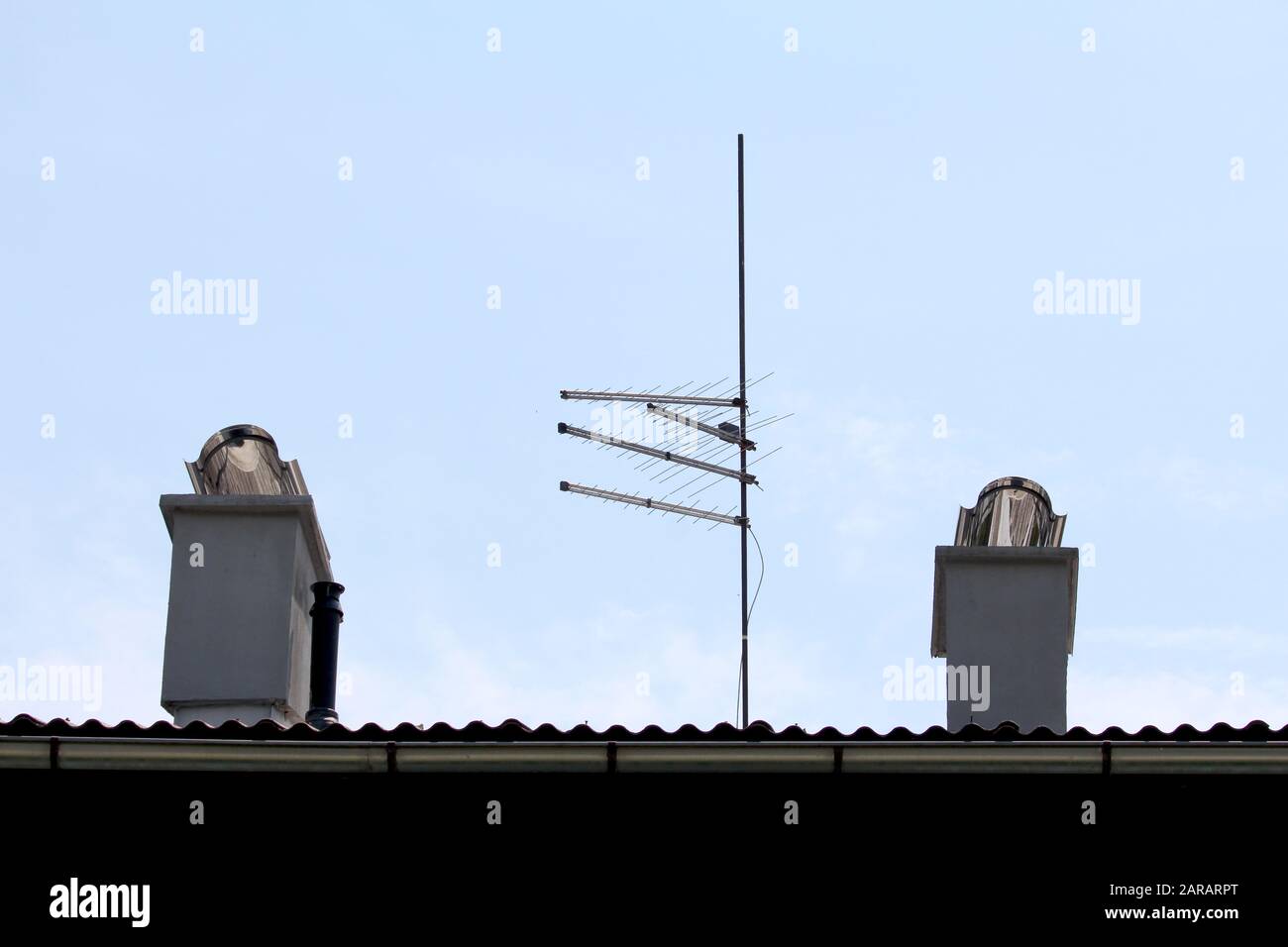 Four TV antennas mounted on strong metal pole on top of suburban family