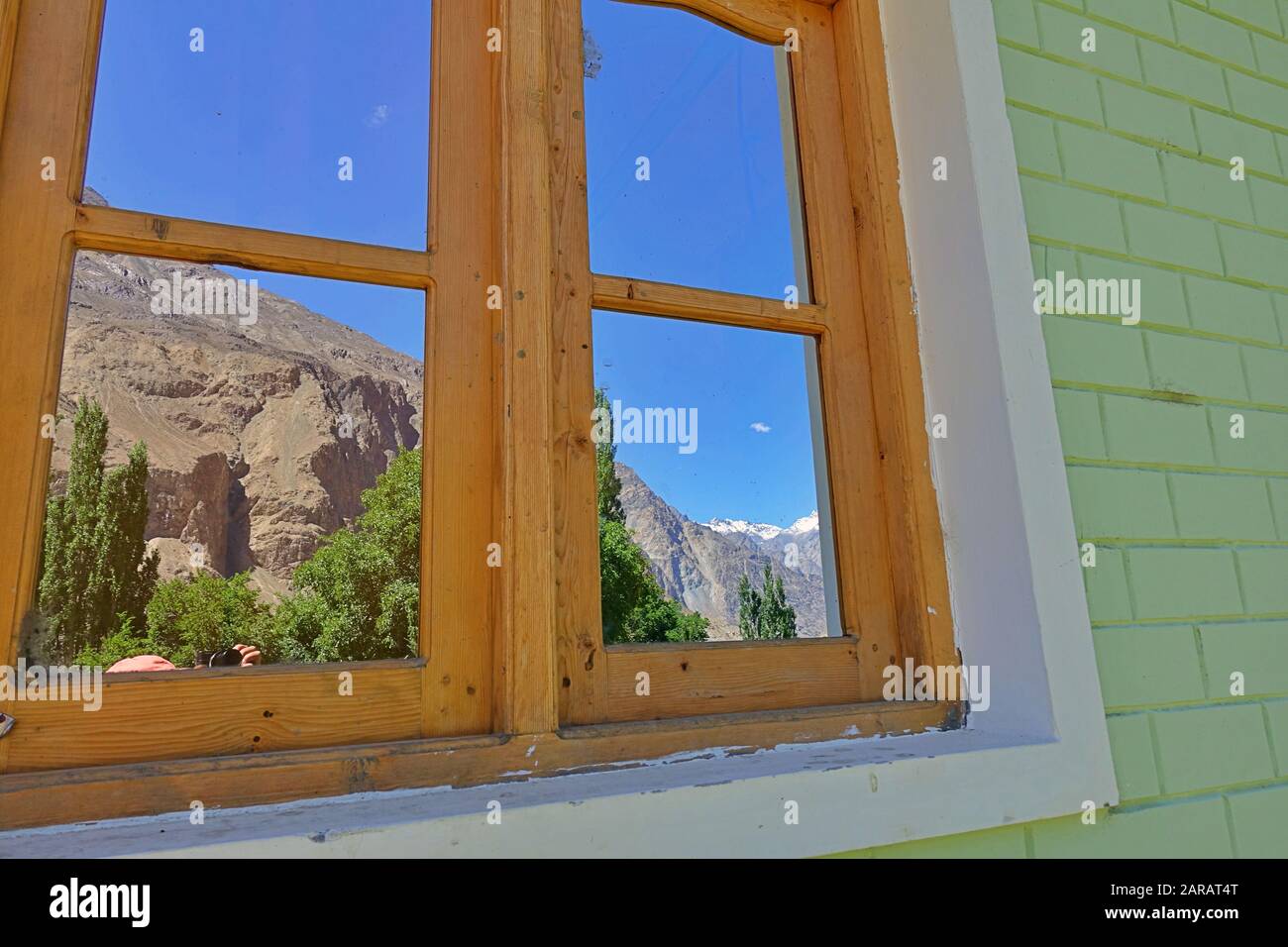 Reflection of Turtuk village and Himalayan mountains in old Window - Leh district of Ladakh, India Stock Photo