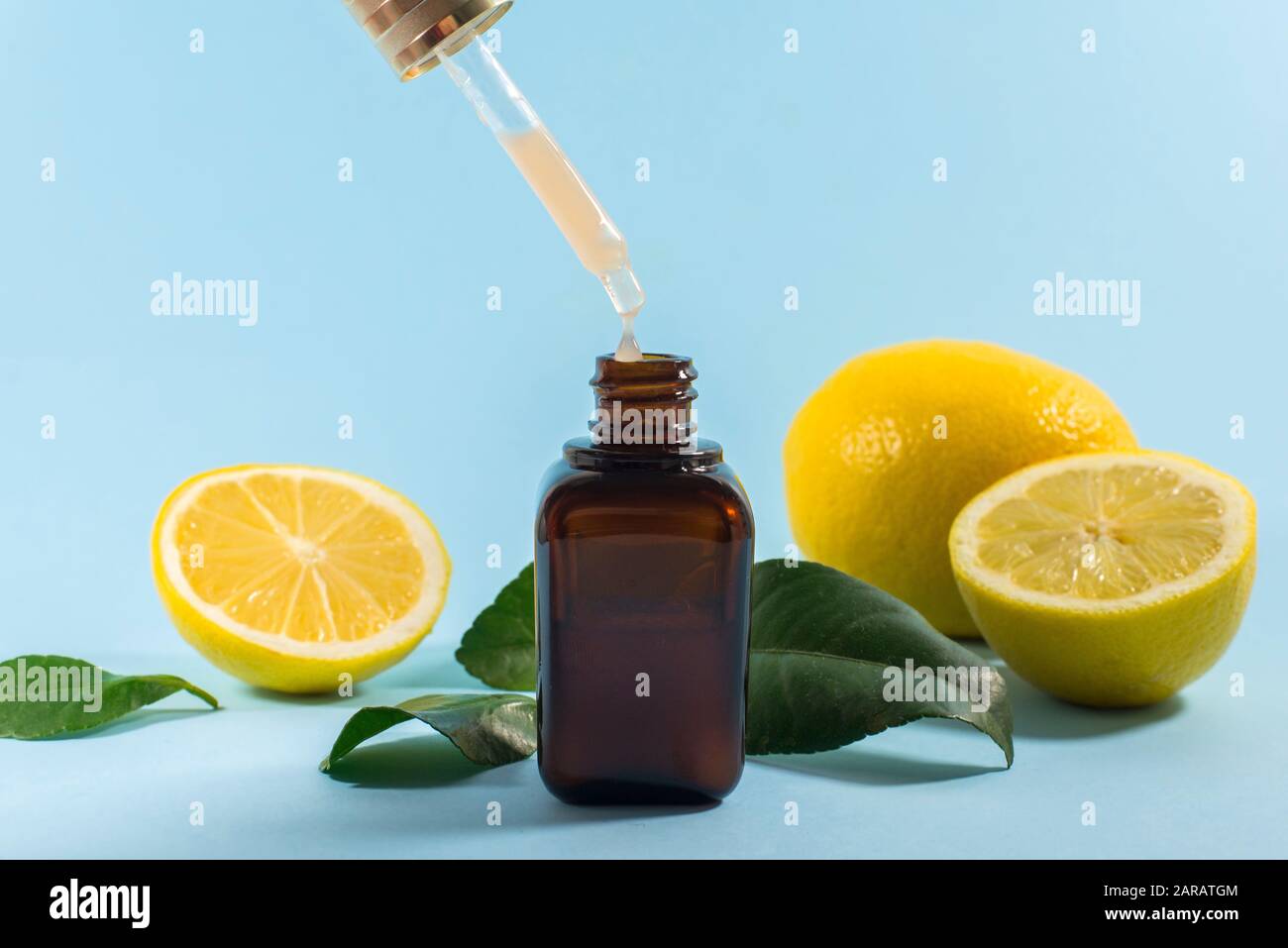 Vitamin C serum. Close up pipette with drop, citrus fruit essential oil