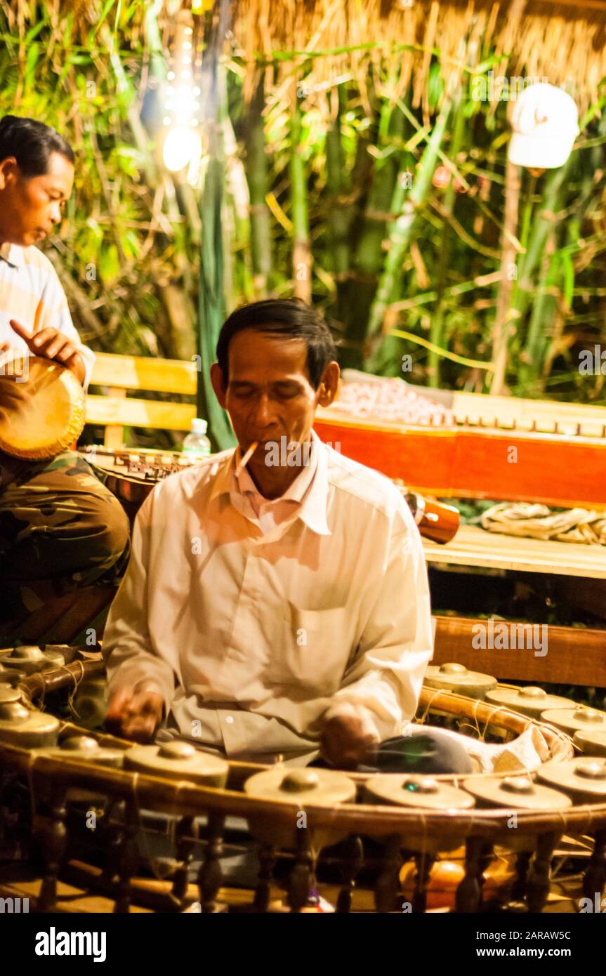 Musicians in the percussion part of a traditional Khmer music group. The man in front is playing the kong vong toch (gong) Stock Photo