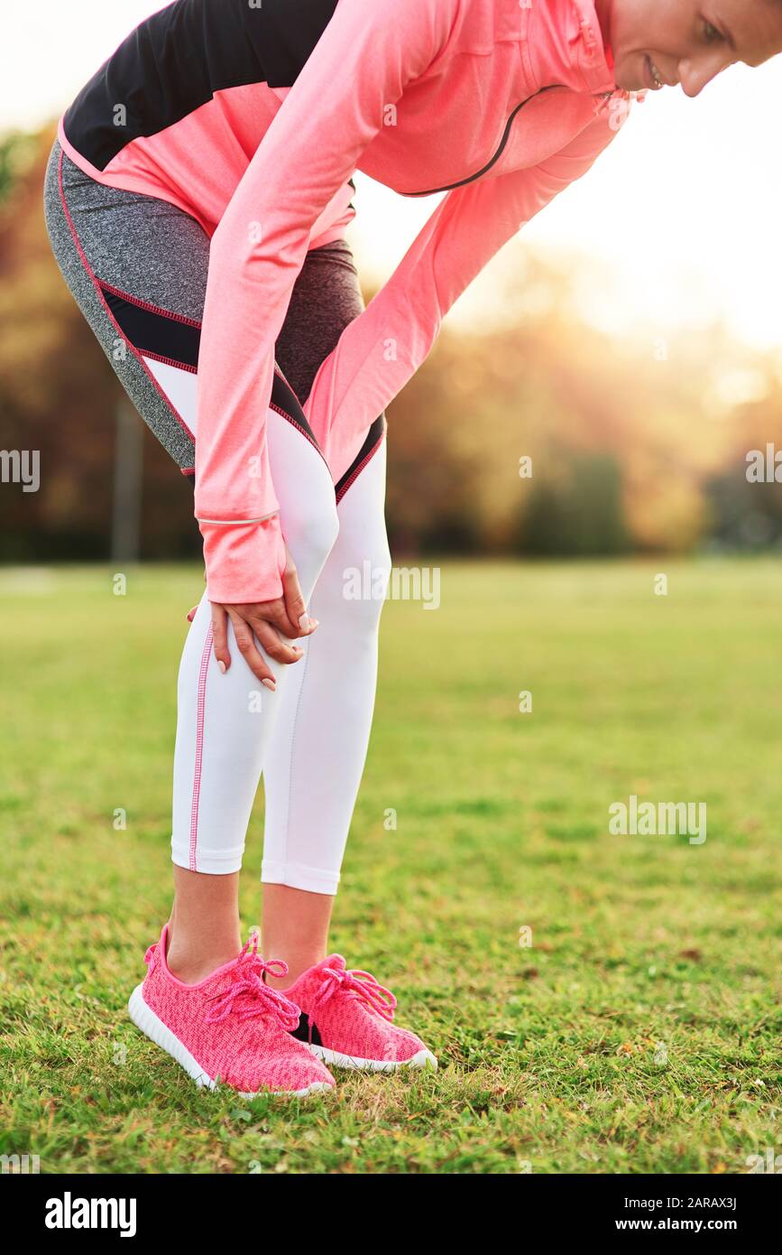 Close up of female athlete suffering from calf pain Stock Photo