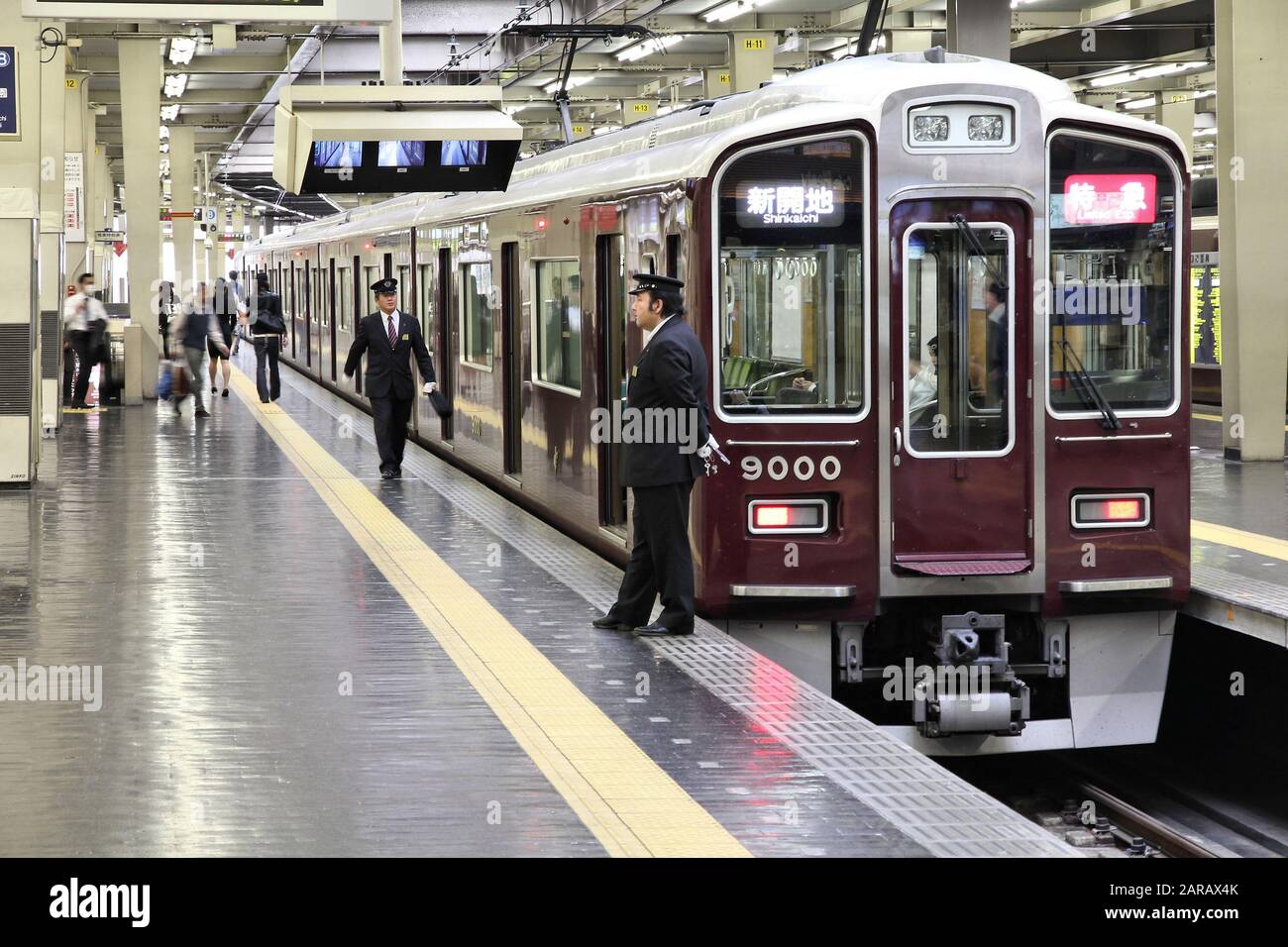 OSAKA, JAPAN - APRIL 24, 2012: People board train at Osaka Hankyu Umeda Station in Osaka, Japan. It is the busiest station in Western Japan serving av Stock Photo