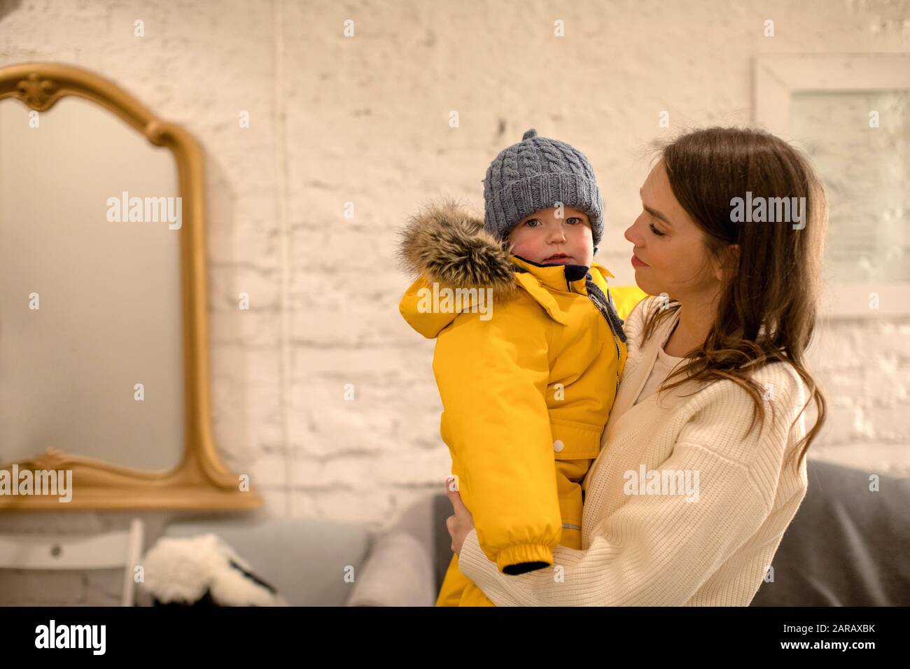 Mother with little child in warm clothing in arms Stock Photo
