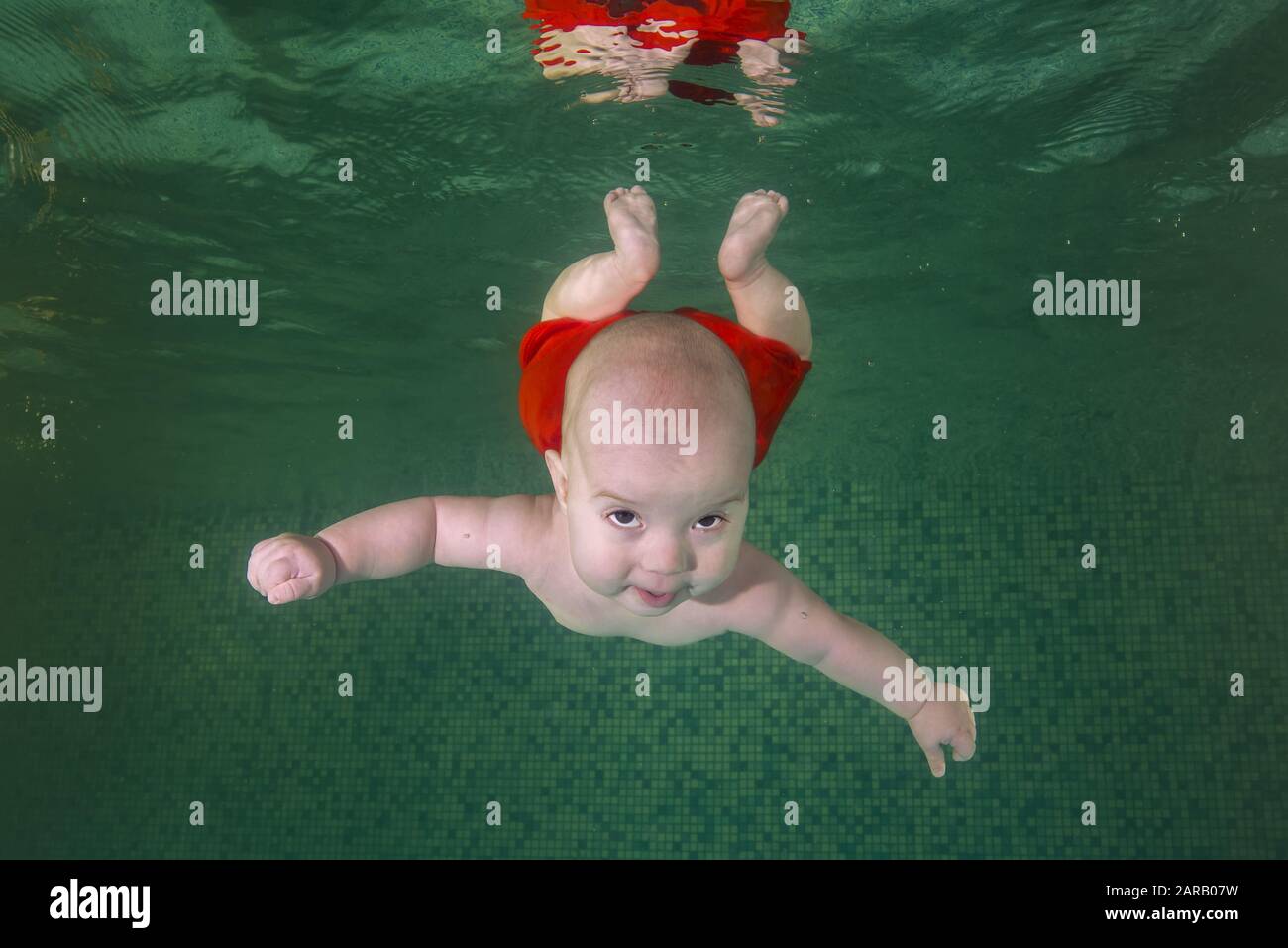 Little baby boy learns to swims underwater. Baby swimming underwater in