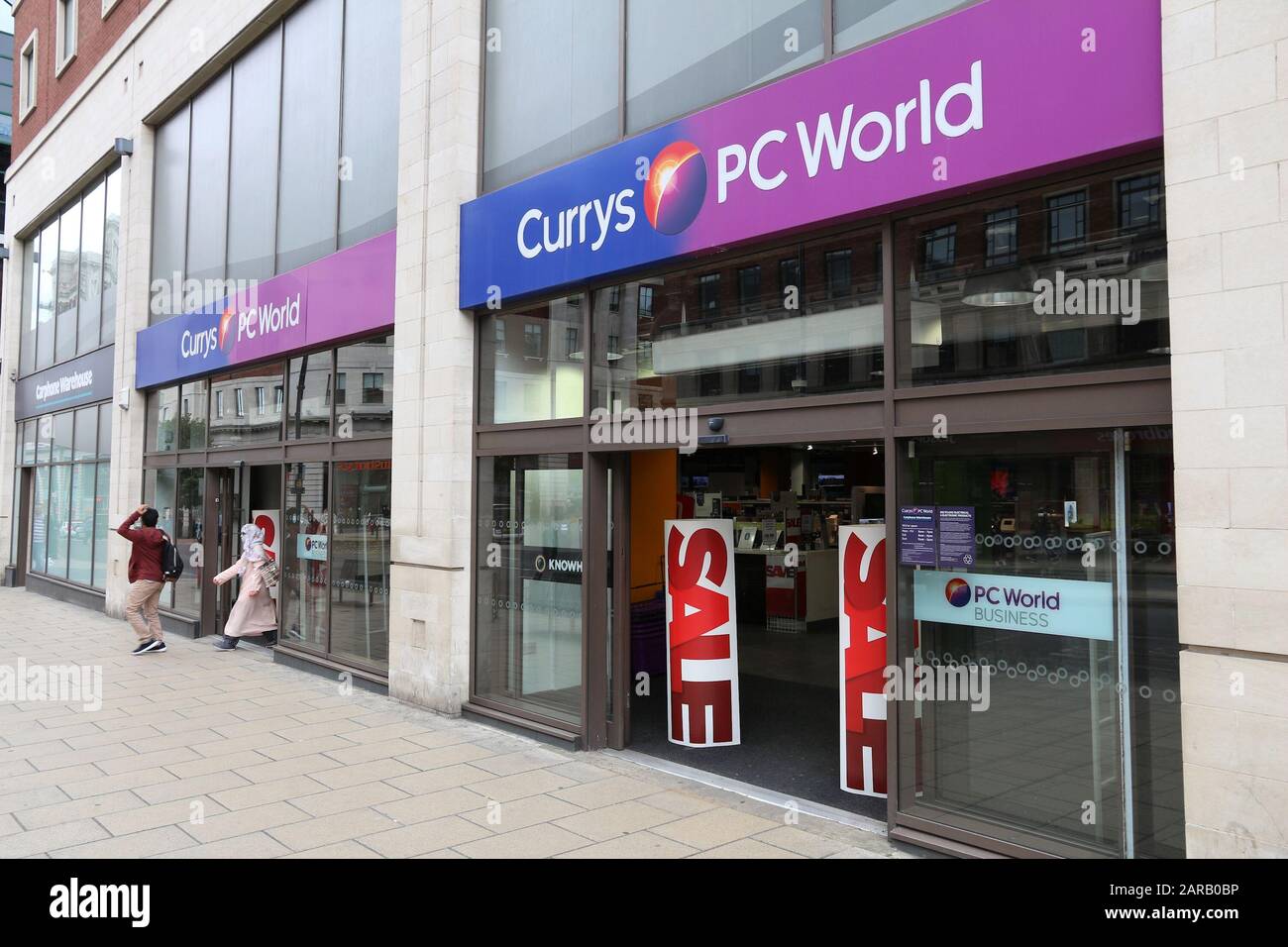 LEEDS, UK - JULY 12, 2016: People walk by Currys PC World computer shop in Leeds, UK. The store chain is owned by Dixons Carphone, a British group. Stock Photo