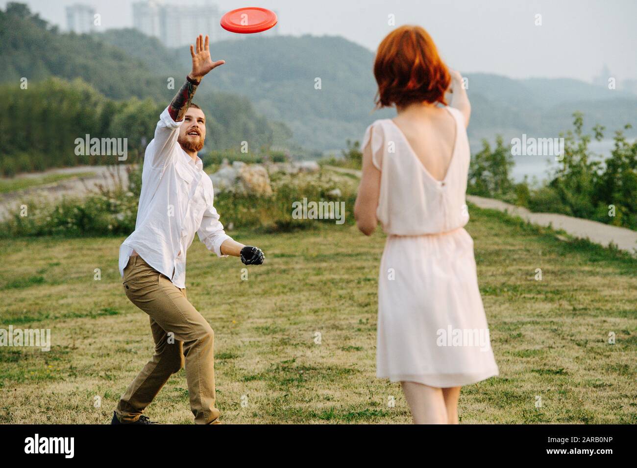Frisbee Ridges Man and woman playing frisbee in a park next to a river and forest ...