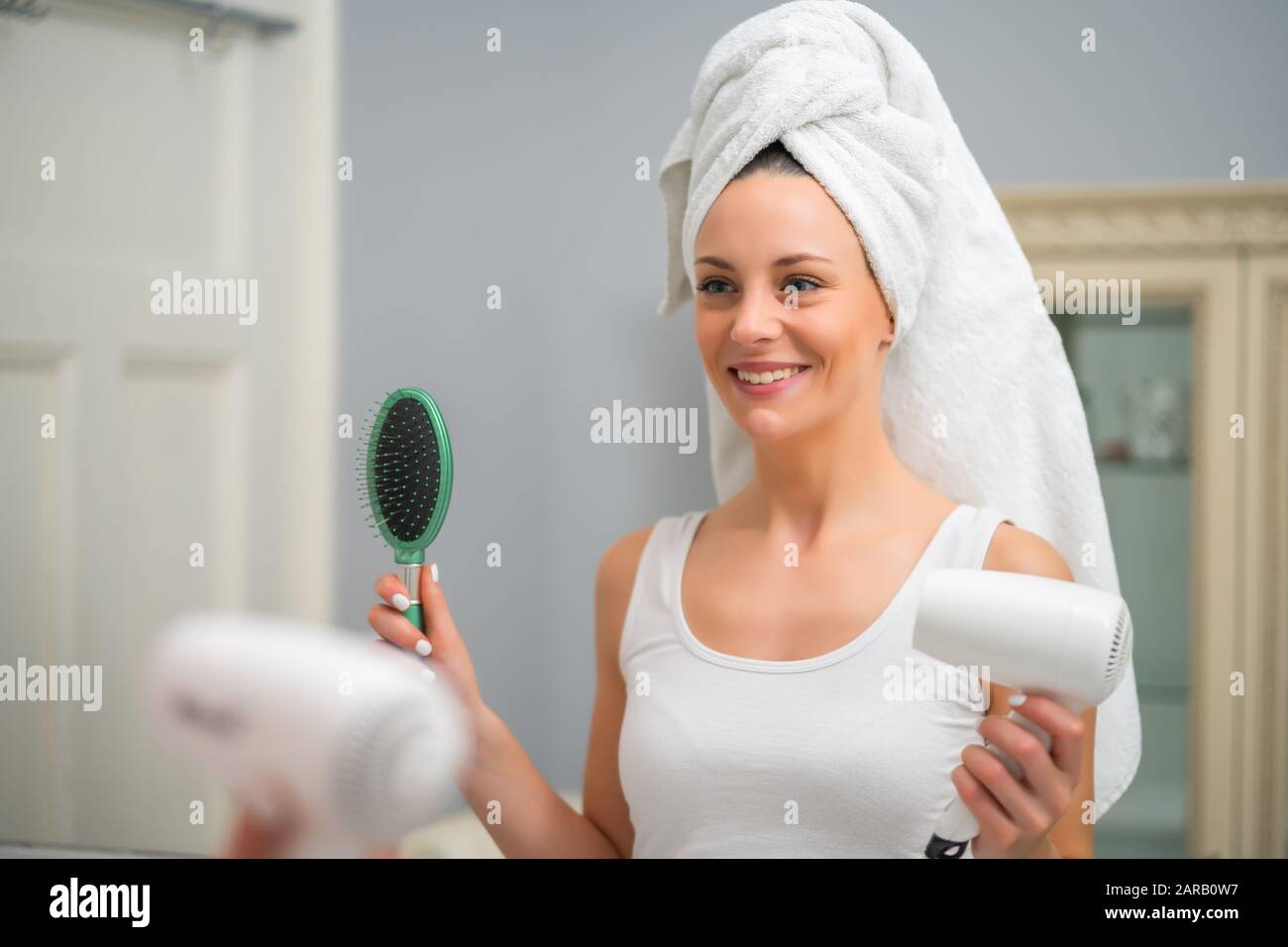 Portrait of young happy woman who is ready to dry her hair Stock Photo ...