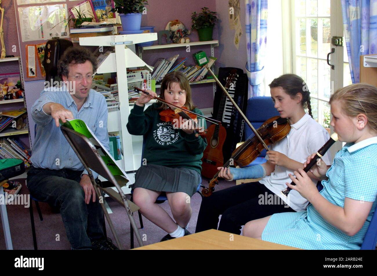 Primary school children playing instruments in class Stock Photo