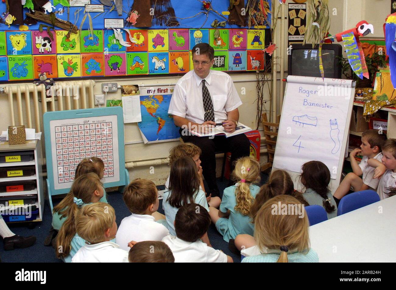 Male teacher teaching uniformed primary students Stock Photo