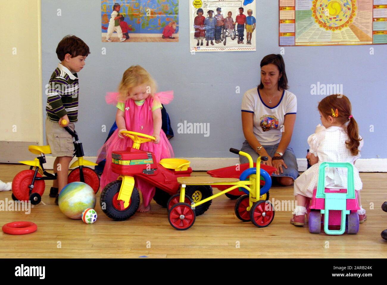 primary school children playing with tricycles and toys Stock Photo