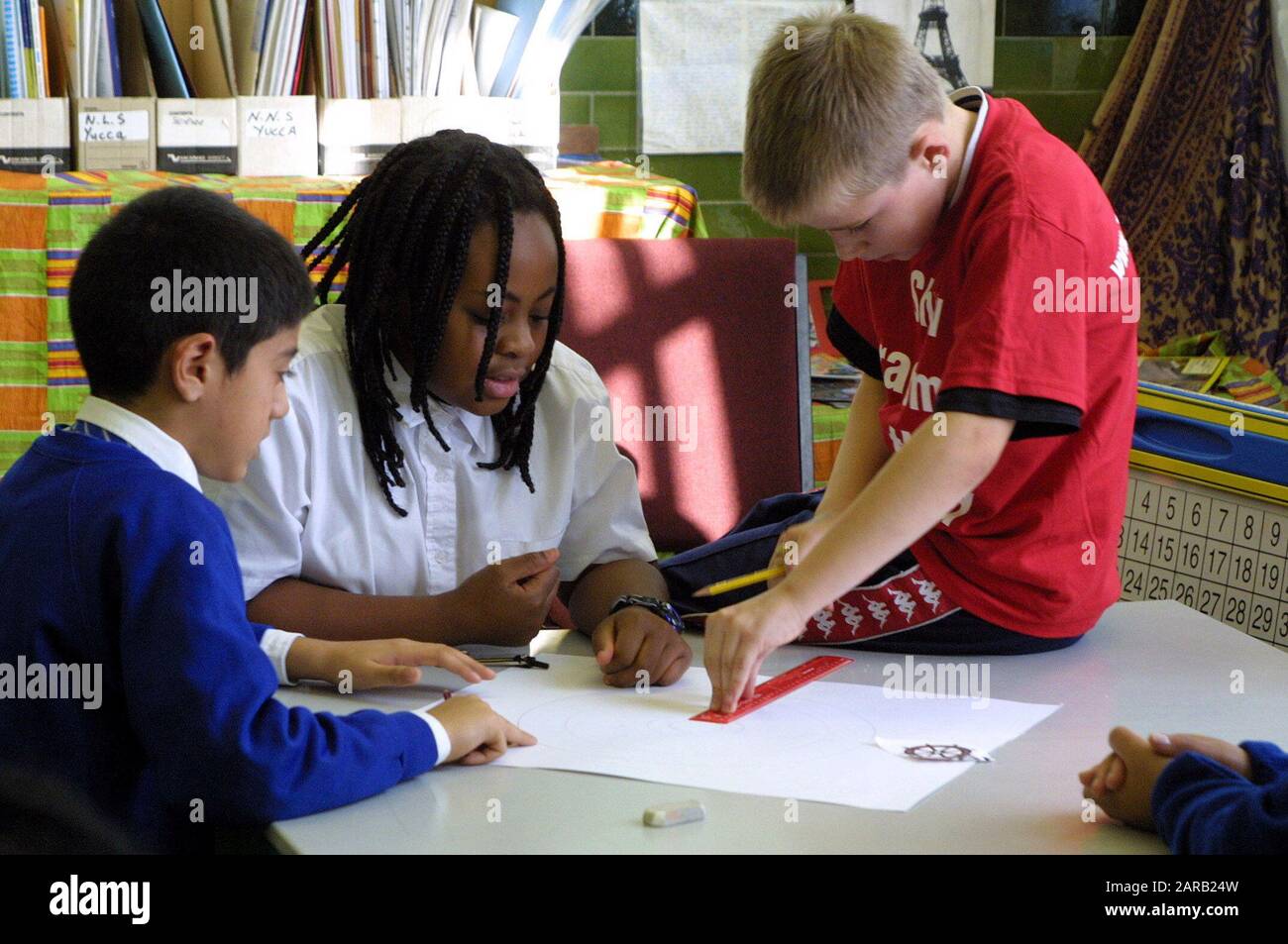 Primary students working together on a math problem using measurements Stock Photo