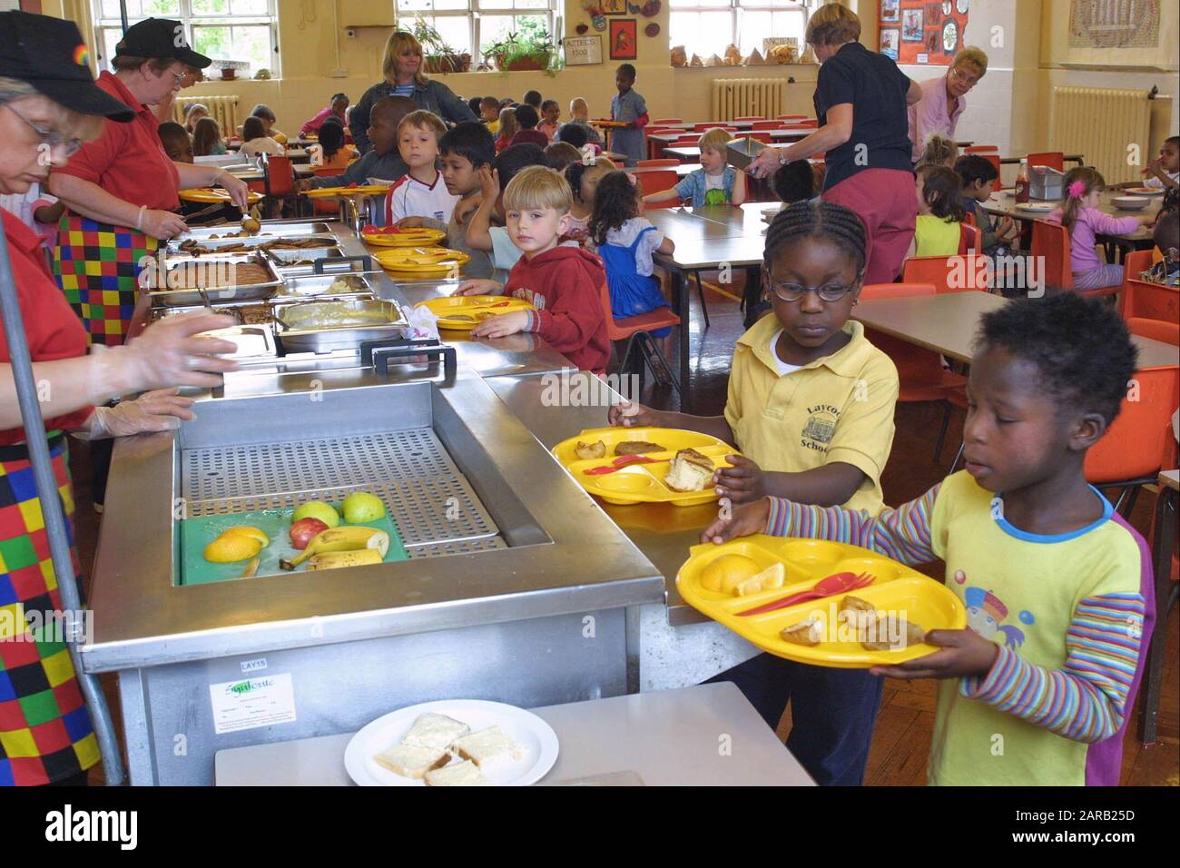 Children in village school canteen being served cooked meal Stock Photo -  Alamy