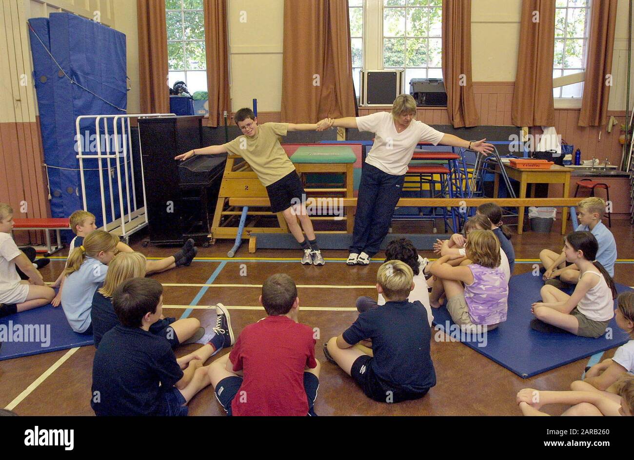 Primary school children doing gymnastics in gym class Stock Photo