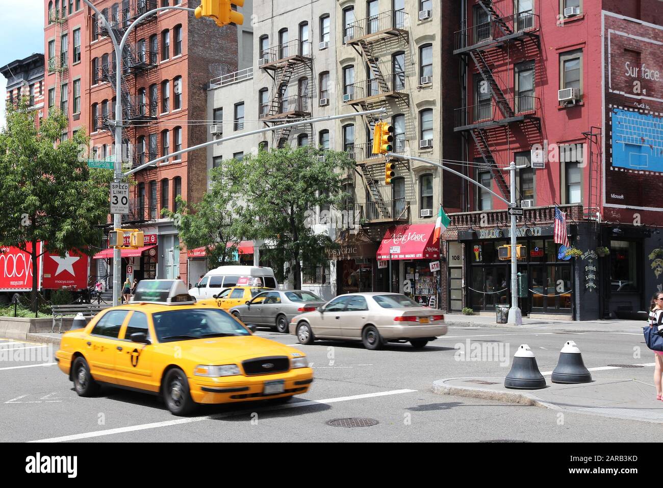 NEW YORK, USA - JULY 2, 2013: People ride yellow taxi in SoHo, New York. As of 2012 there were 13,237 yellow taxi cabs registered in New York City. Stock Photo